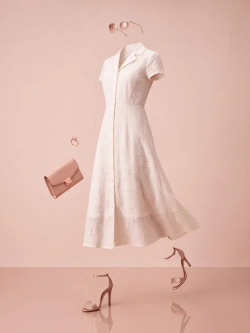 The same dress as a ghost mannequin image — an invisible figure mid-stride in a blush studio with floating accessories